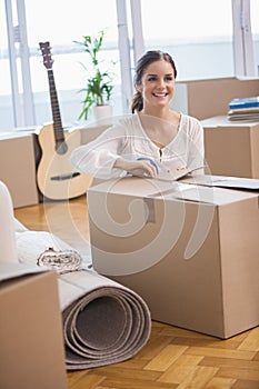 Smiling woman unpacking cardboard boxes