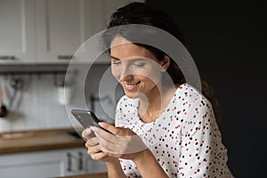 Smiling woman use cellphone texting online on gadget