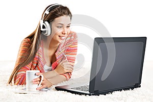Smiling Woman use Laptop in Headphone. Young Girl work on Computer at Home. Happy Student Study in Earphone lying down