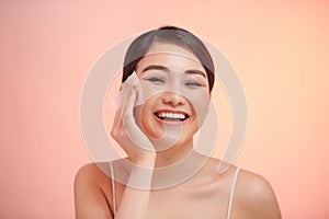 Smiling woman using facial oil blotting paper portrait