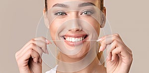 Smiling Woman Using Floss Cleaning Teeth Posing Over Beige Background