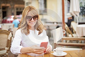 Smiling woman using her mobile phone