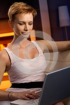 Smiling woman using laptop computer at home