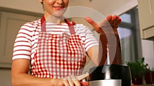 Smiling woman using a mixer