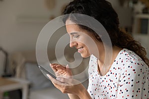 Smiling woman using modern smartphone messaging online