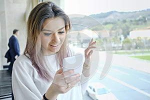 Smiling woman using phone in the office.