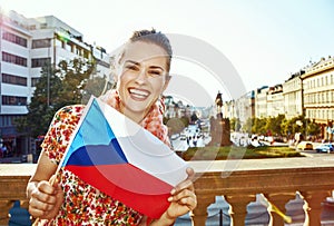 Smiling woman on Vaclavske namesti in Prague showing flag