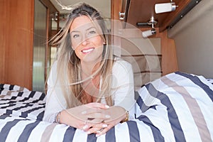 Smiling woman during vanlife in camper van interior motor home