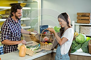 Smiling woman with vendor at the counter at grocery store