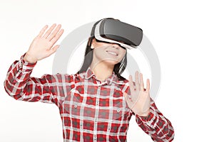 Smiling woman in VR headset touching air by hands.