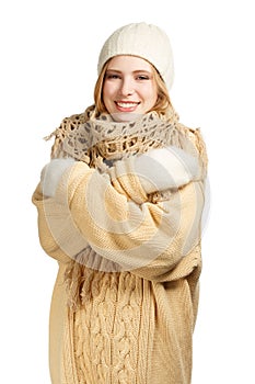 Smiling woman in warm clothing hugging herself