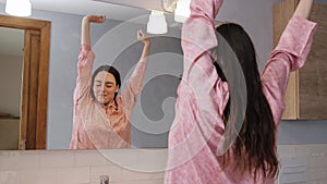 Smiling Woman washing her face in the bathroom.