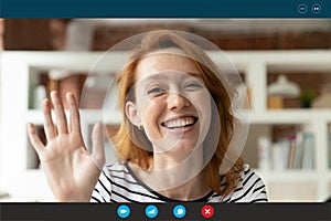 Smiling woman wave to camera talking on video call