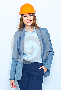 Smiling woman wearing a building helmet standing against white