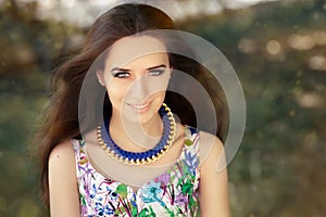 Smiling Woman Wearing Floral Dress and Big Necklace