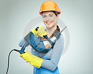 Smiling woman wearing helmet holding drill tool.