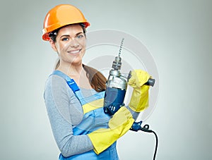 Smiling woman wearing helmet holding drill tool.