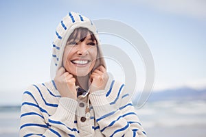 Smiling woman wearing hooded sweater during winter