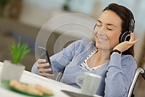 smiling woman in wheelchair using phone