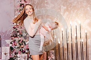 Smiling woman whirls with baby in arms for Christmas