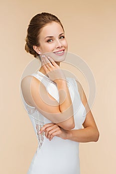 Smiling woman in white dress with diamond ring