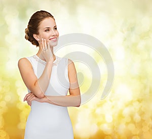 Smiling woman in white dress wearing diamond ring