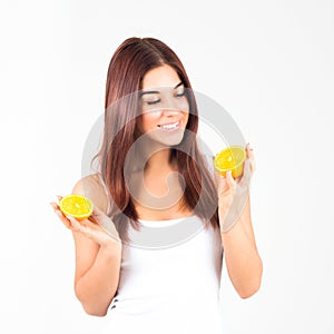 Smiling woman with white teeth holding two halfs of orange. Woman looks at orange. Healty food.