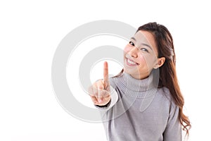 Smiling woman in winter outfit showing no.1 or one finger gesture