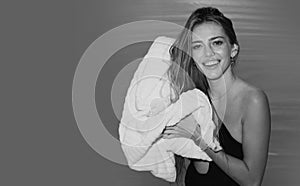 Smiling woman wiping hair with towel in the pool. Elegant sexy woman with towel posing near the swimming pool water.