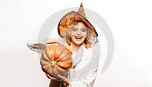 Smiling Woman in Witch hat with pumpkin. Halloween concept.