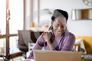 Smiling woman working on laptop at home