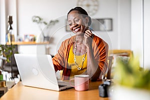 Smiling woman working on laptop at home