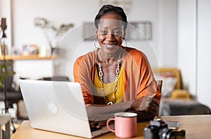 Smiling woman working on laptop at home