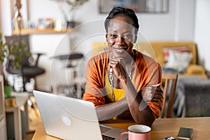 Smiling woman working on laptop at home