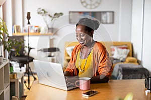 Smiling woman working on laptop at home