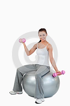 A smiling woman working out with dumbbells