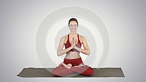 Smiling woman yoga meditating sitting lotus, hands coupled on gradient background.