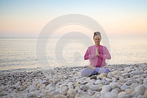 Smiling woman yoga meditation siddhasana lotus namaste hands sea sunset beach sky horizon landscape