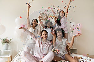 Smiling women group wear sleepwear celebrate party throw confetti up