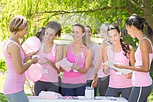 Smiling women organising event for breast cancer awareness