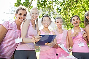 Smiling women organising event for breast cancer awareness