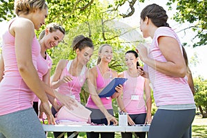 Smiling women organising event for breast cancer awareness