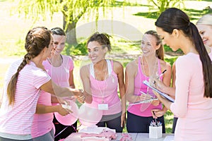 Smiling women organising event for breast cancer awareness