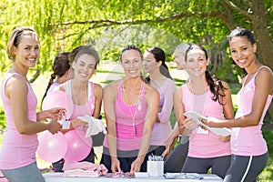 Smiling women organising event for breast cancer awareness