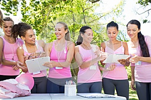 Smiling women organising event for breast cancer awareness