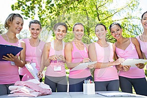 Smiling women organising event for breast cancer awareness