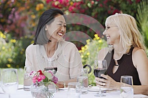 Smiling Women At Outdoor Table With Wine Glasses