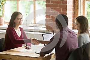 Smiling woman shaking hands with african american HR representat