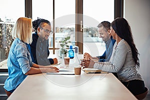 Smiling work colleagues having an office meeting together