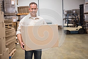 Smiling worker carrying a box